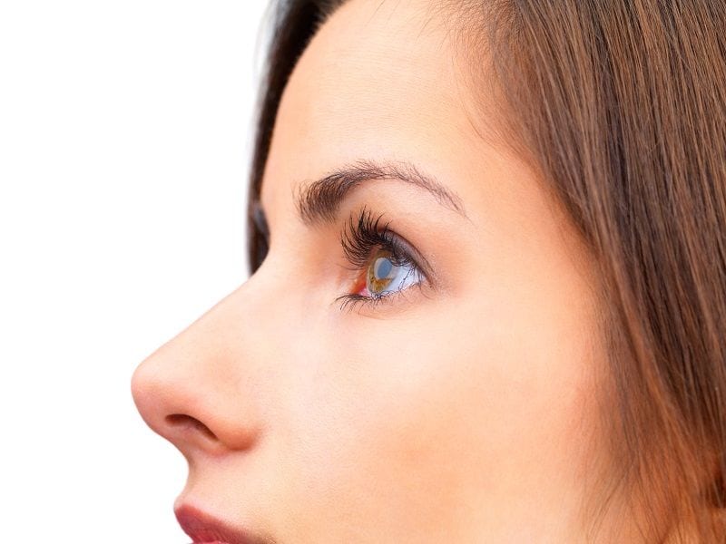 Closeup profile image of a young brunette on white